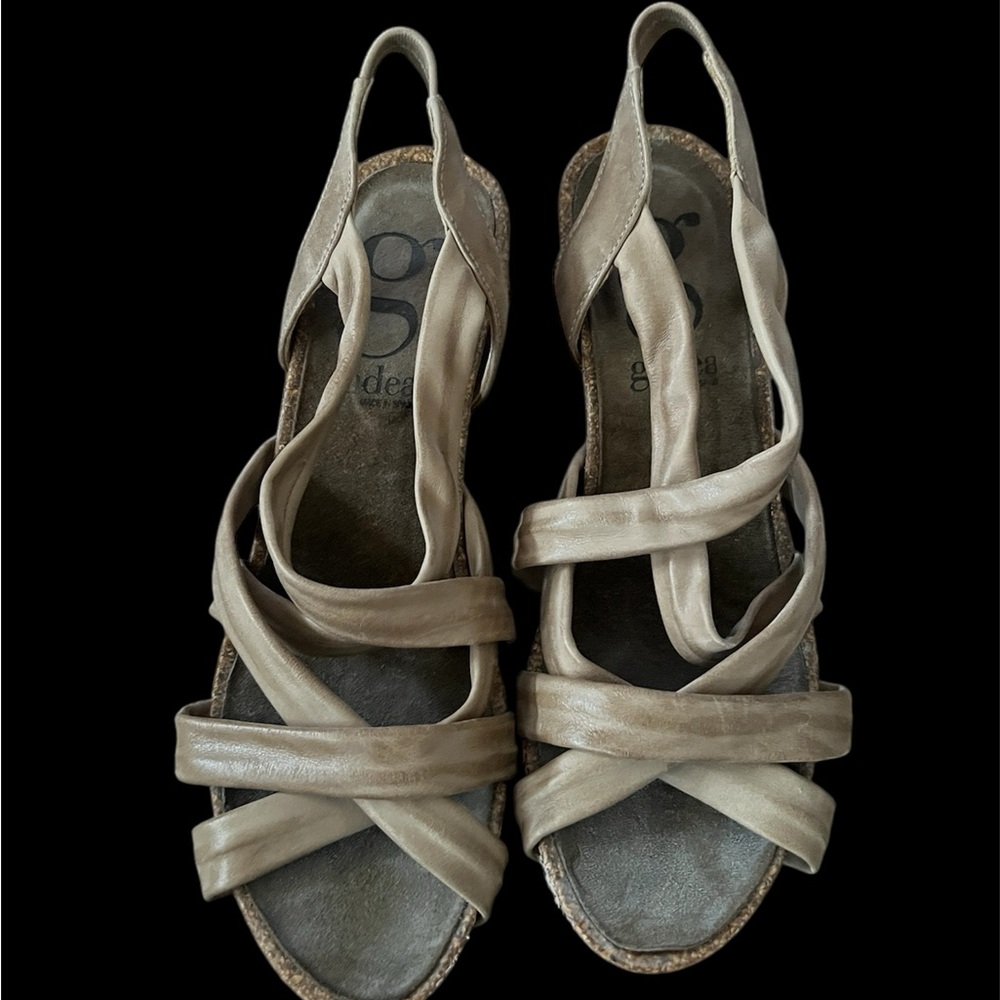 Tan sandals with open-toe design and intricate strap pattern